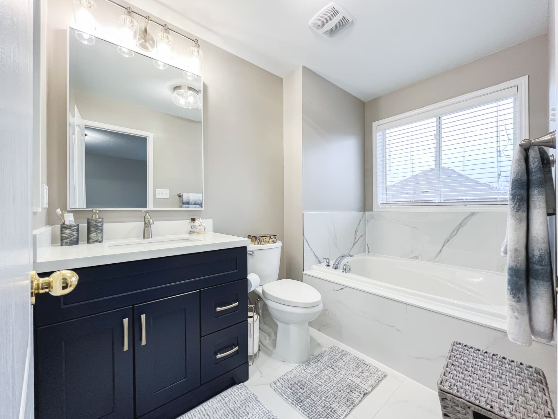 Bright renovated bathroom with a large-format tiled bath surround
